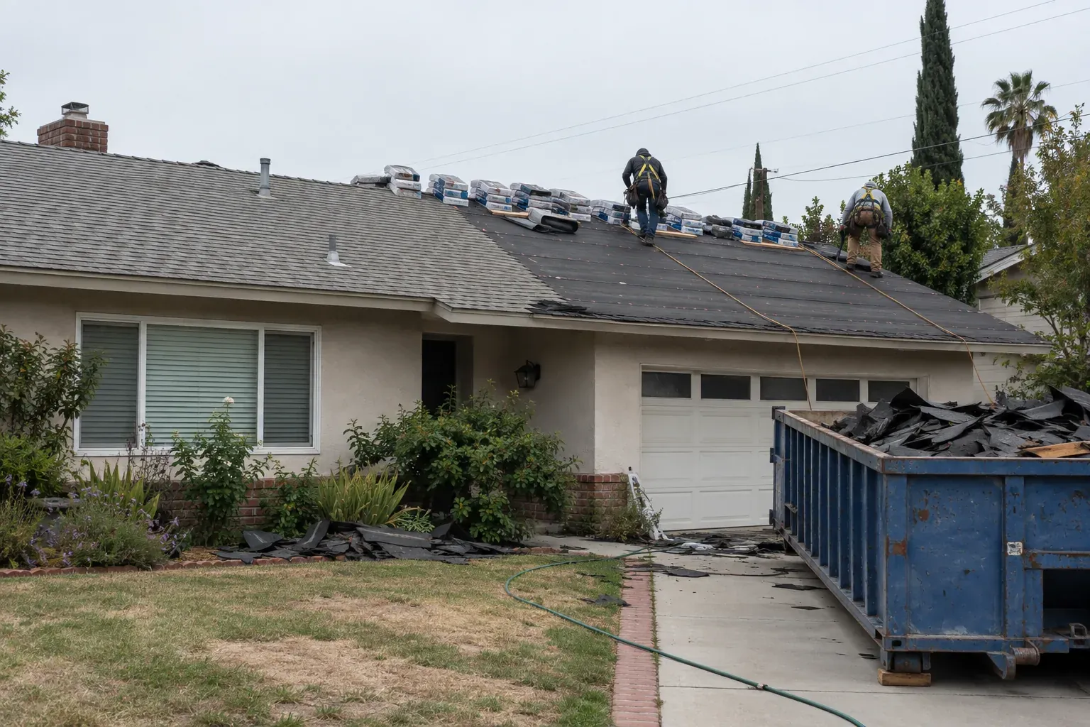Roofers replacing an asphalt shingle roof on a Los Angeles ranch house
