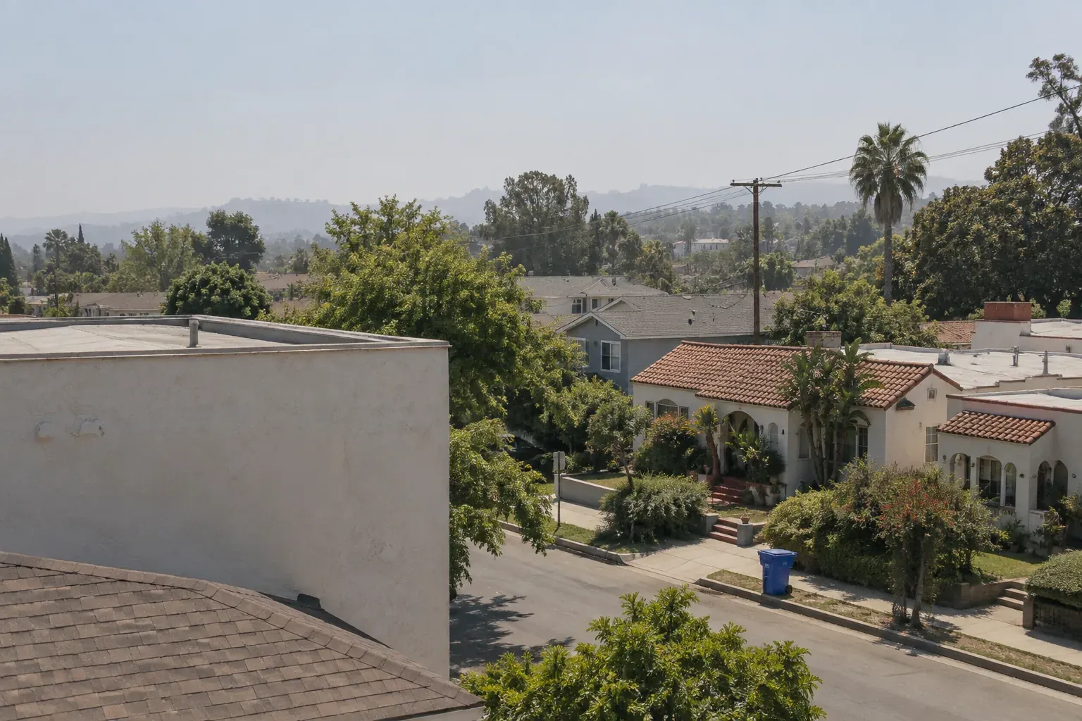 Row of tile, shingle and flat roofs along a Los Angeles street